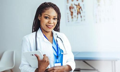 Women's health nurse practitioner with a DNP smiling with clipboard in clinic